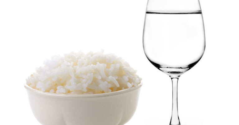 Rice in a bowl and Glass of water on a white background