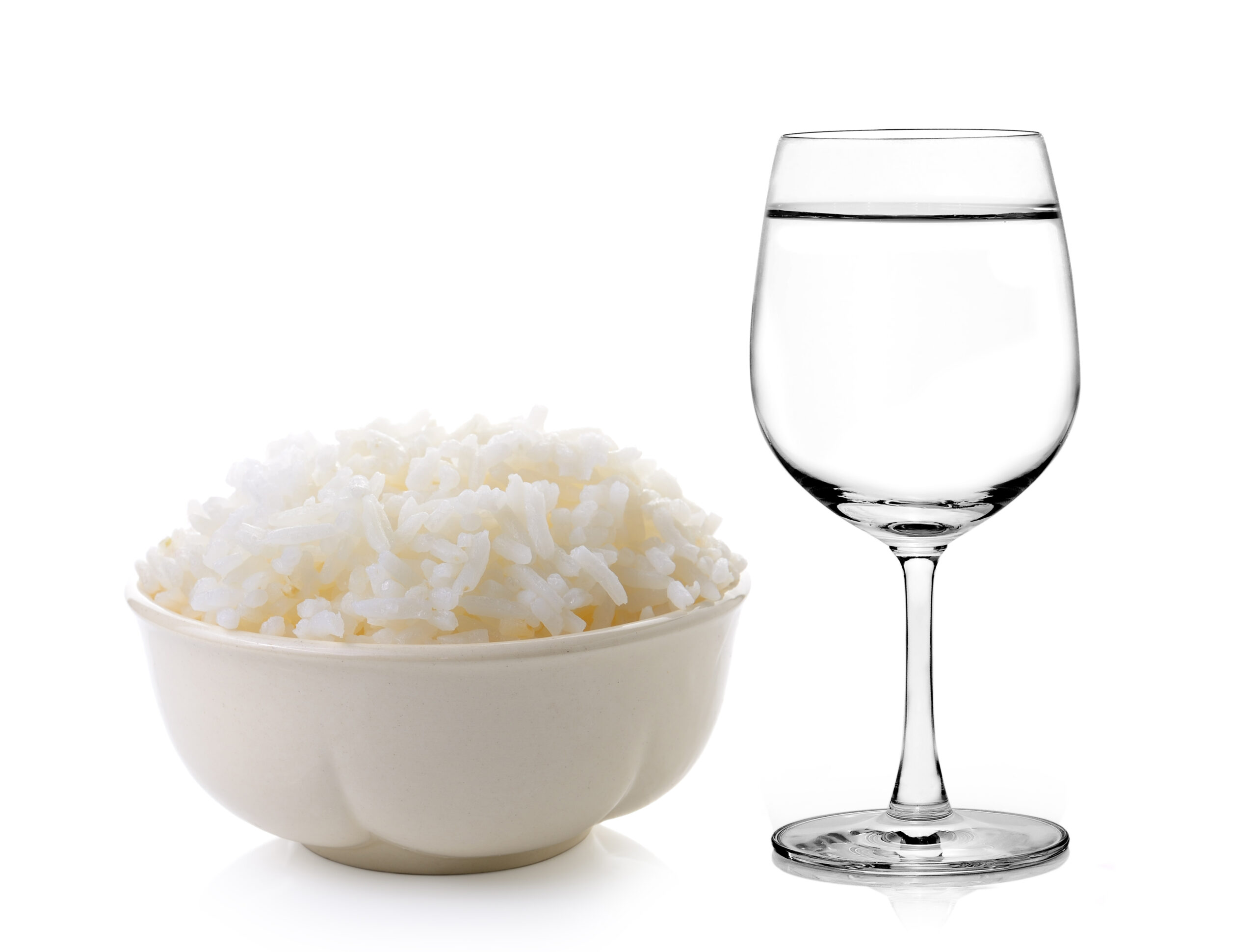 Rice in a bowl and Glass of water on a white background Rice in a small bowl and Glass of water on a white background