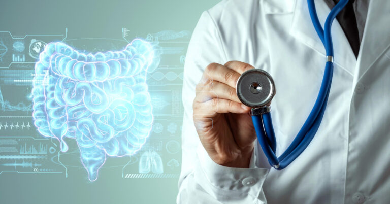A doctor with a stethoscope stands next to a digital illustration of a human digestive system.